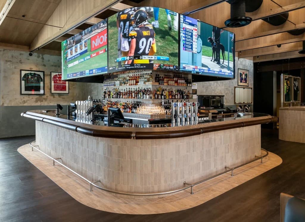 Modern sports bar venue with wraparound screens showing live sport